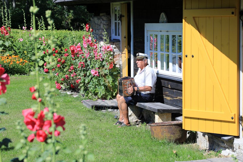 Mann mit Akkordeon im Garten, Saaremaa, Estland