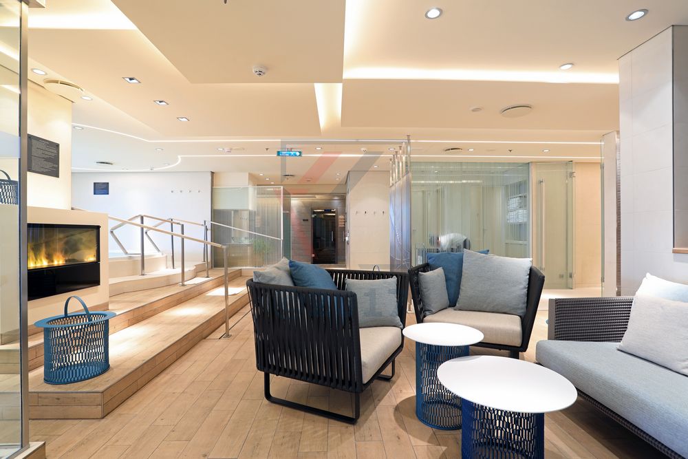 MS Europa 2 im Ocean Spa mit Lounge-Ecke und Elektro-Kamin