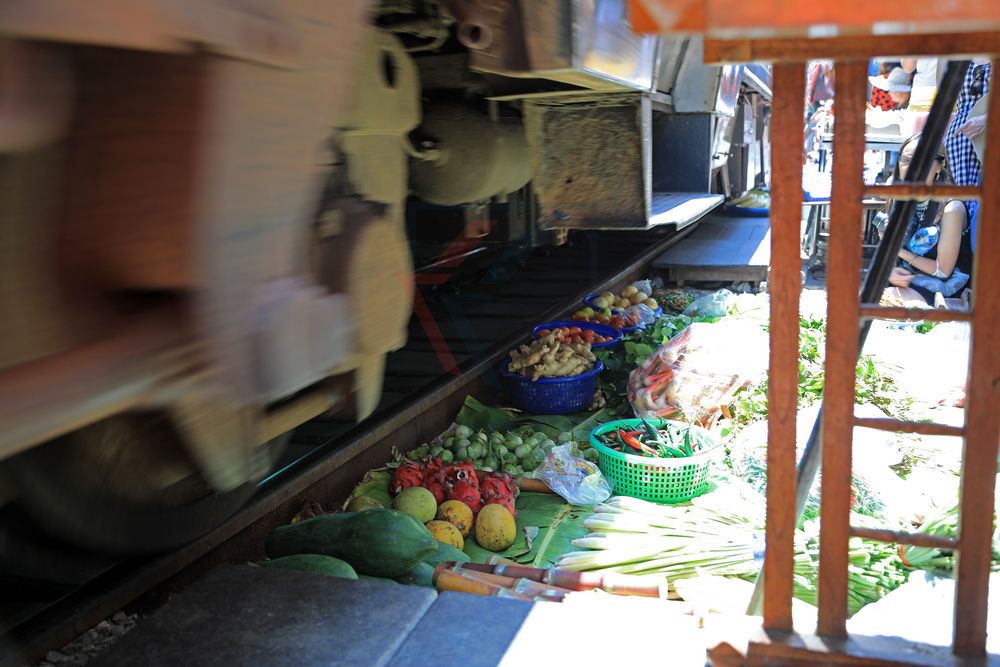 Zug über Ware auf dem Mae Klong Railway Market in Samut Songkhram